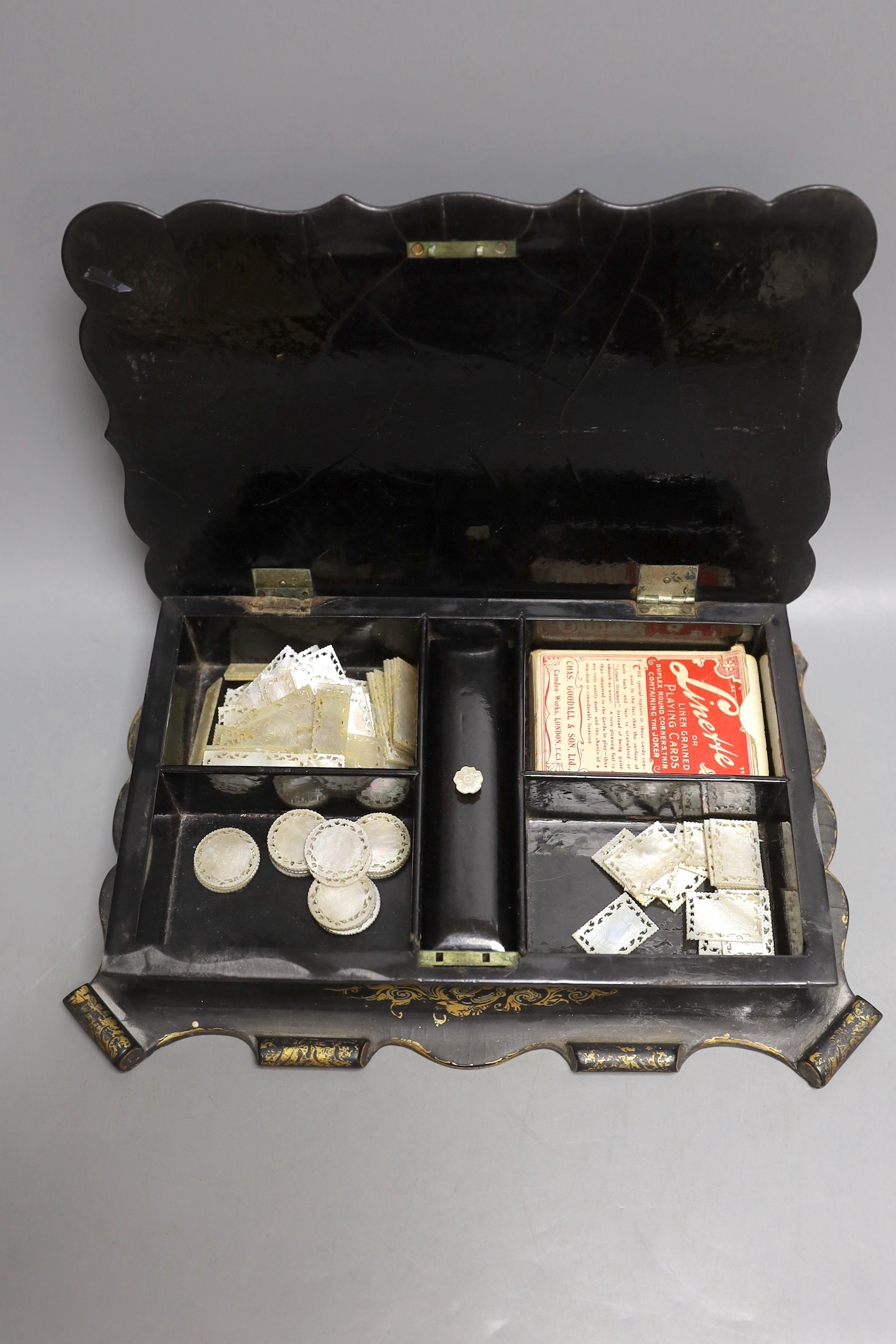 A Victorian papier-mâché games box with mother of pearl inlay and mother-of-pearl counters
